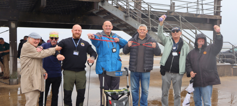 Group posing beneath a seaside pier