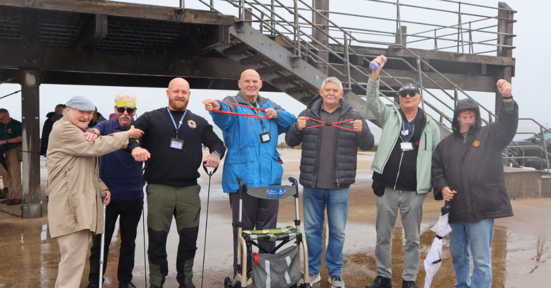 Group posing beneath a seaside pier