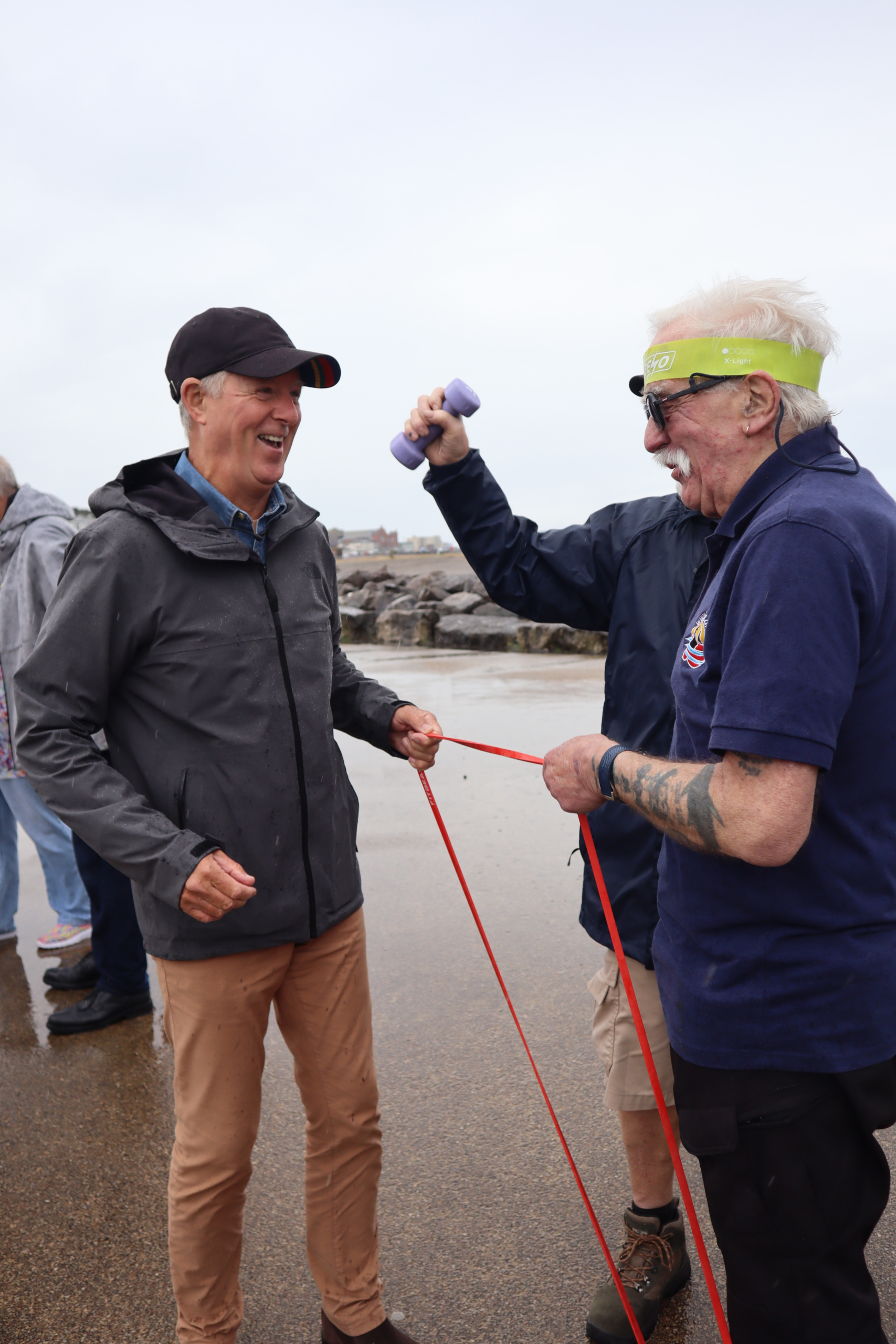 Two men holding a rope by the shore