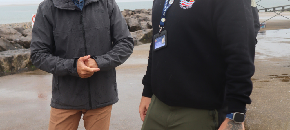 Two men walking beside a seaside building