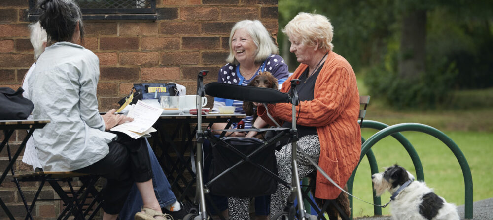 Three ladies with a dog sitting outside at a table at Moor Park