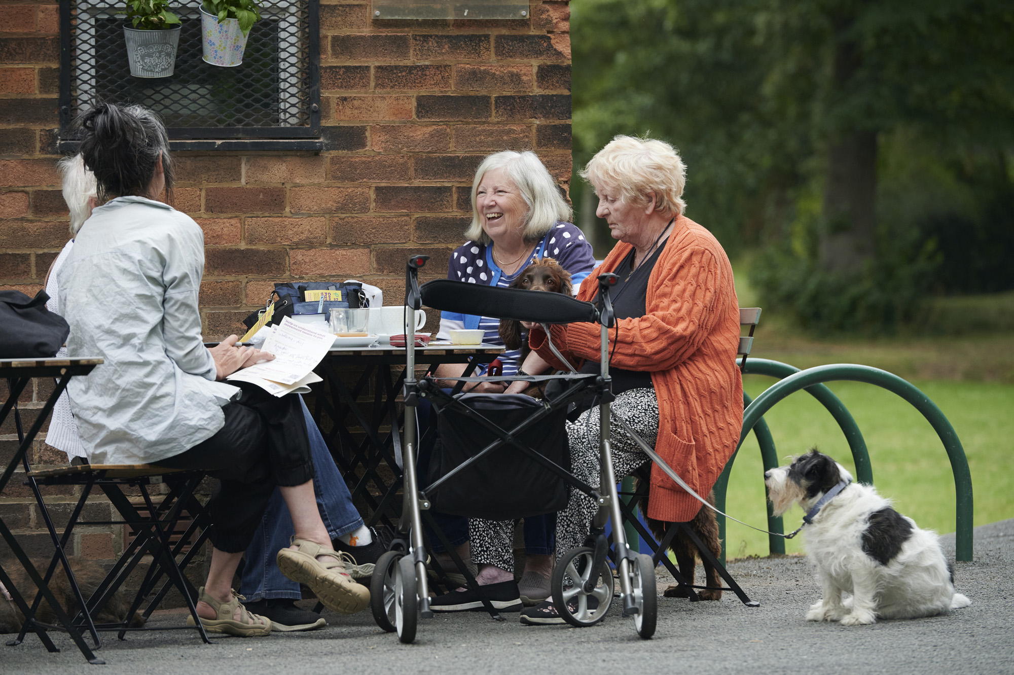 Three ladies with a dog sitting outside at a table at Moor Park
