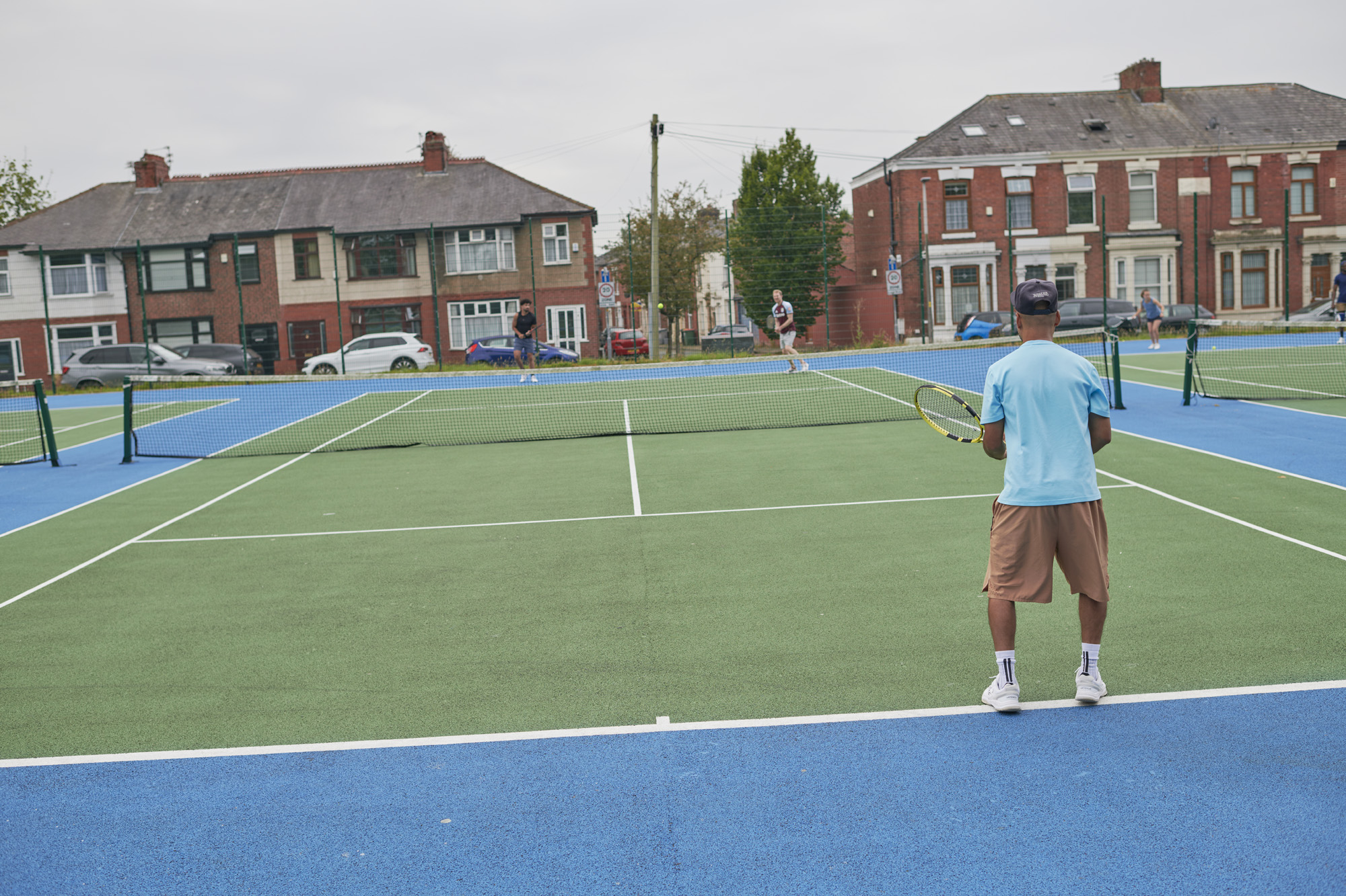 Male standing on tennis court at Moor Park