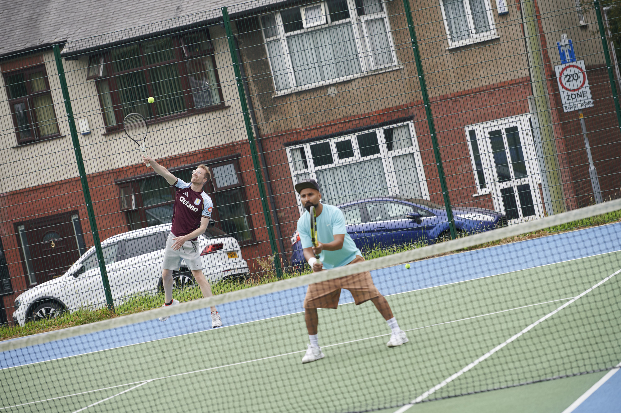 Two males playing tennis on tennis court at Moor Park