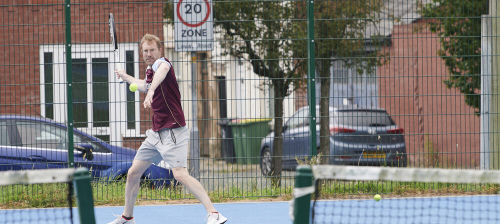 Male playing tennis on tennis court at Moor Park