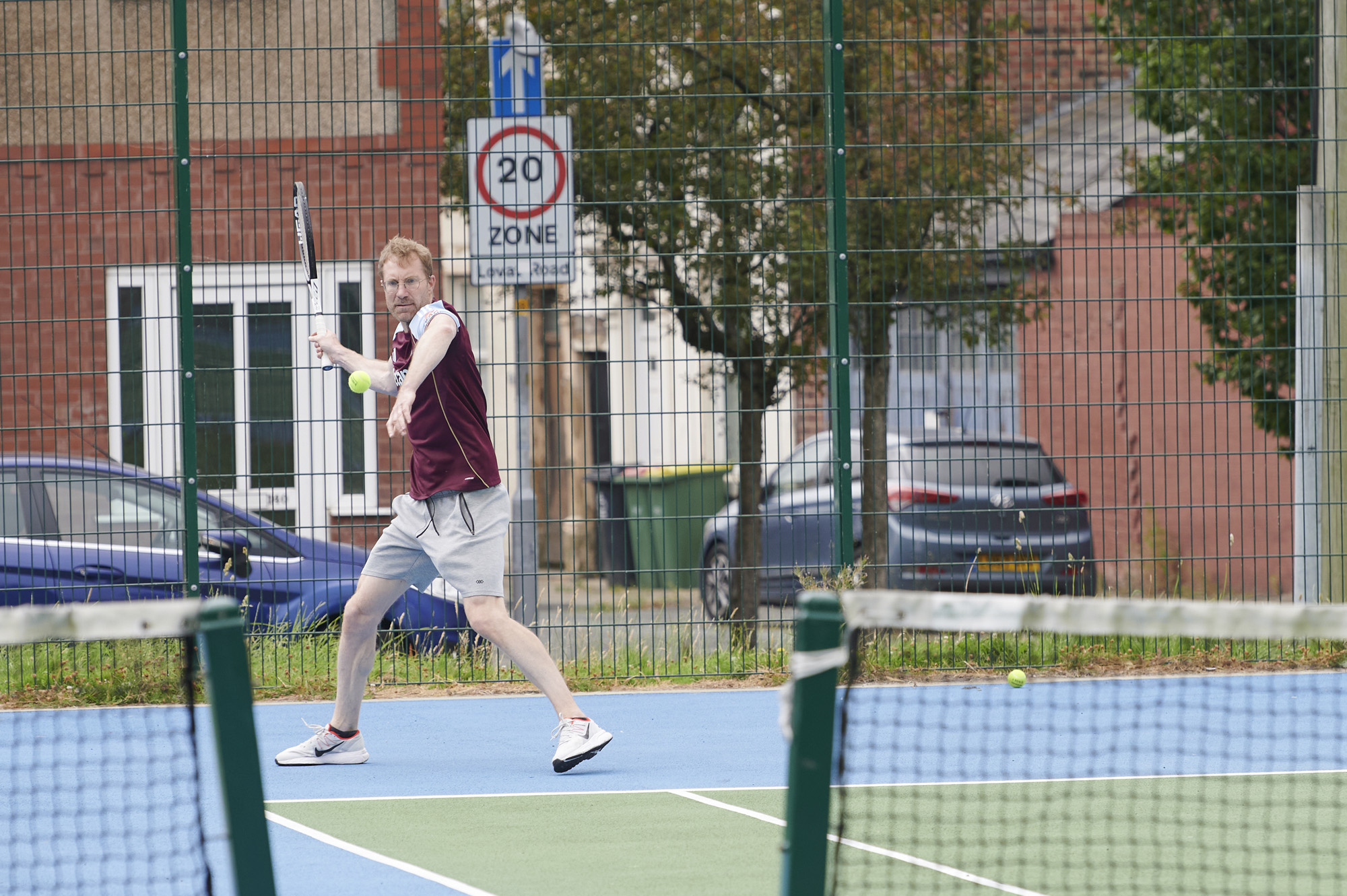 Male playing tennis on tennis court at Moor Park