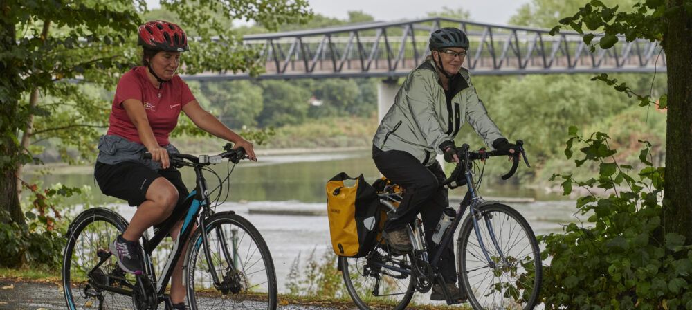 Two females, wearing helmets, cycling in Avenham and Miller Park