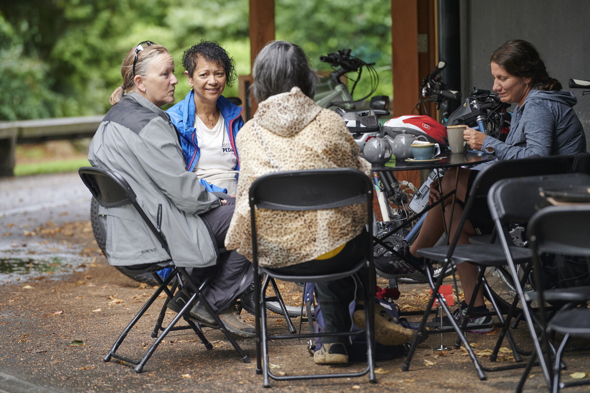 Three ladies sitting talking whilst taking a break on a guided cycle ride from Preston Train Station to Avenham Park, Preston, Lancashire, UK.