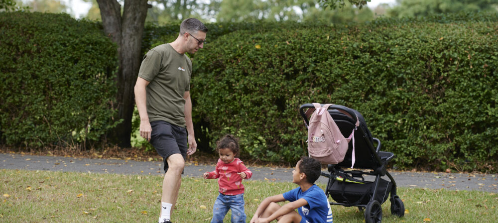 Father playing with a ball with son and daughter on Moor Park