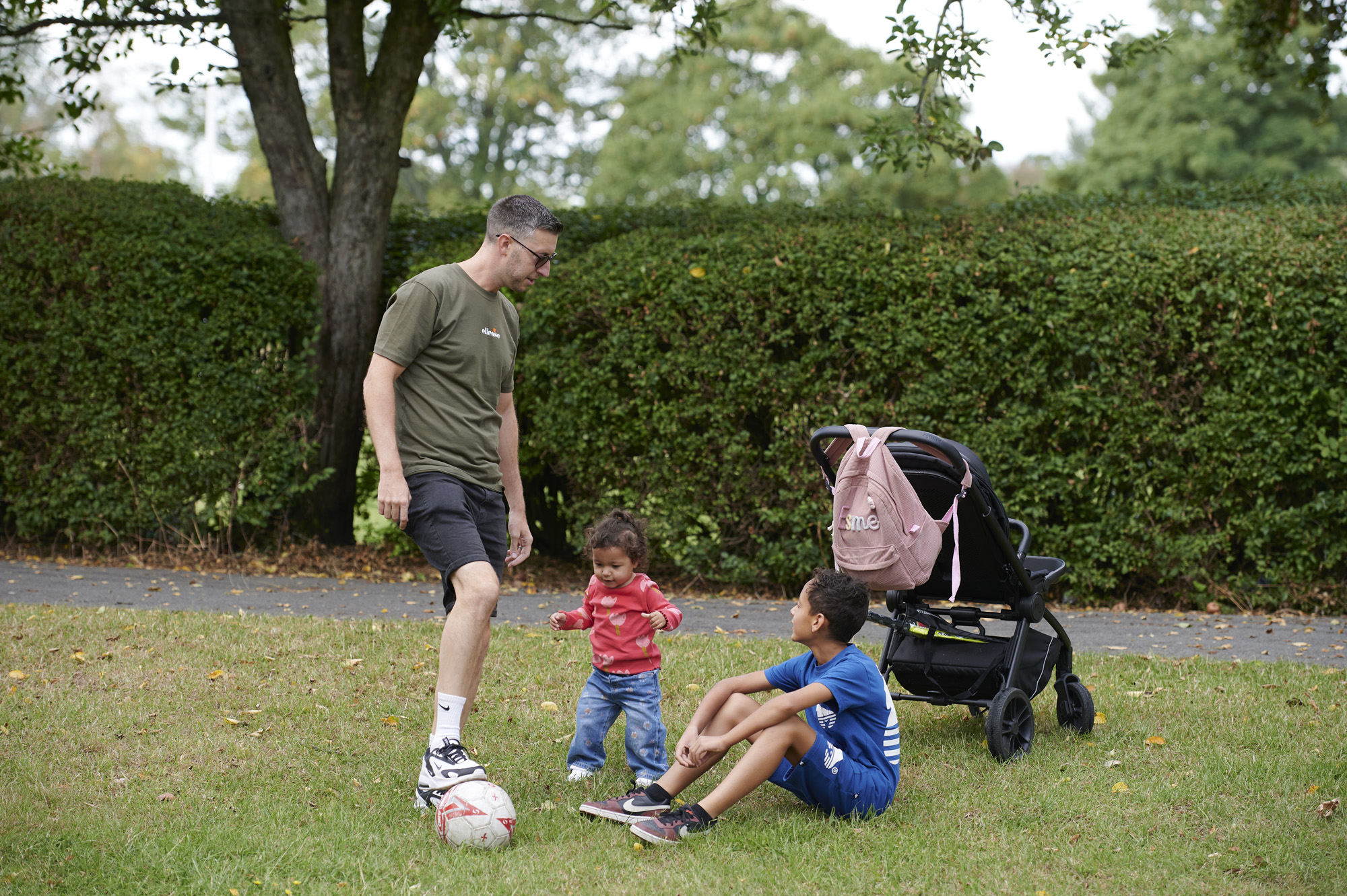 Father playing with a ball with son and daughter on Moor Park