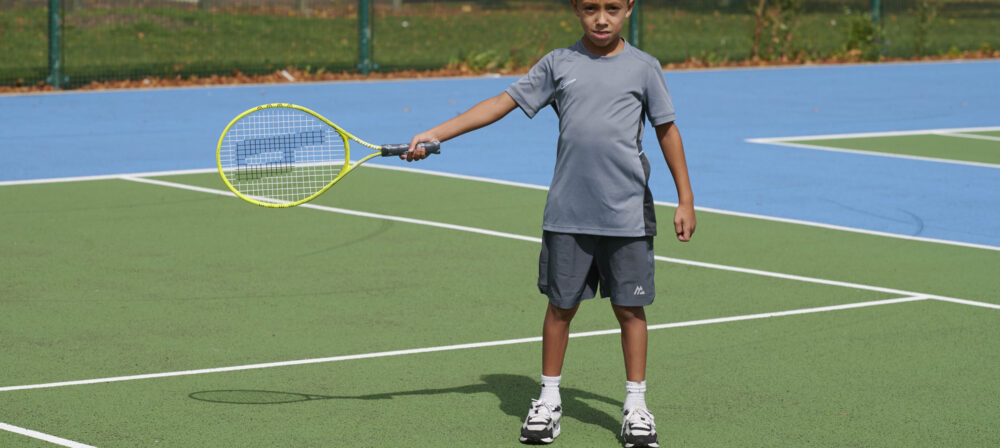 Young boy holding tennis racket on Moor Park Tennis Court