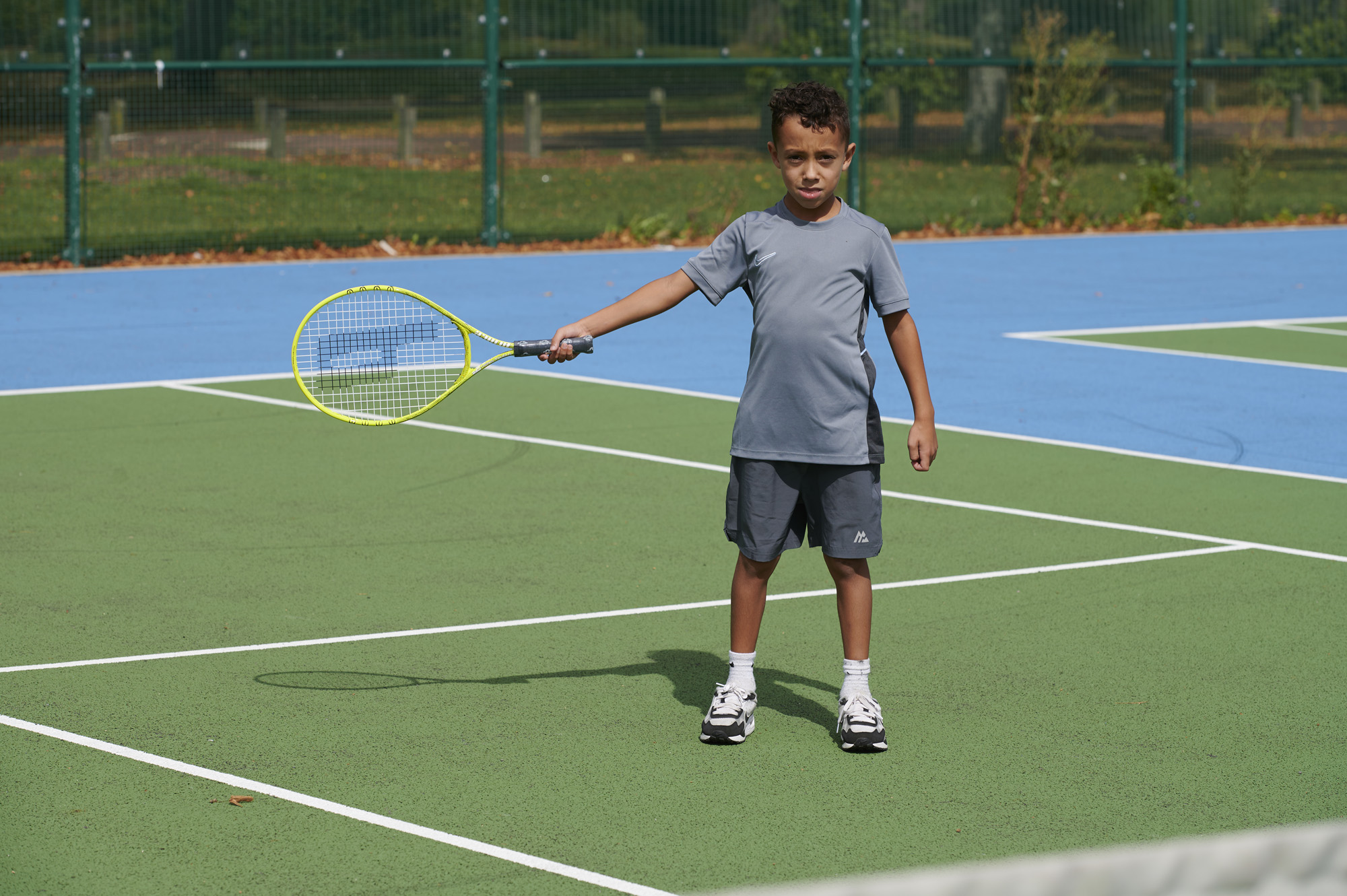 Young boy holding tennis racket on Moor Park Tennis Court
