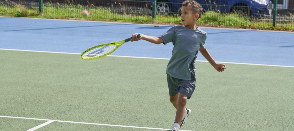 Young male holding tennis racket on tennis courts in Moor Park