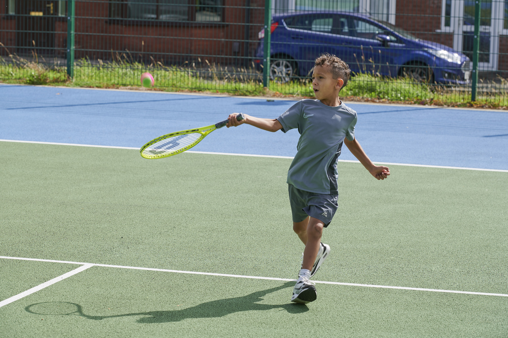 Young male holding tennis racket on tennis courts in Moor Park