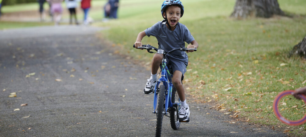 Young boy, wearing helmet, on bike in Moor Park