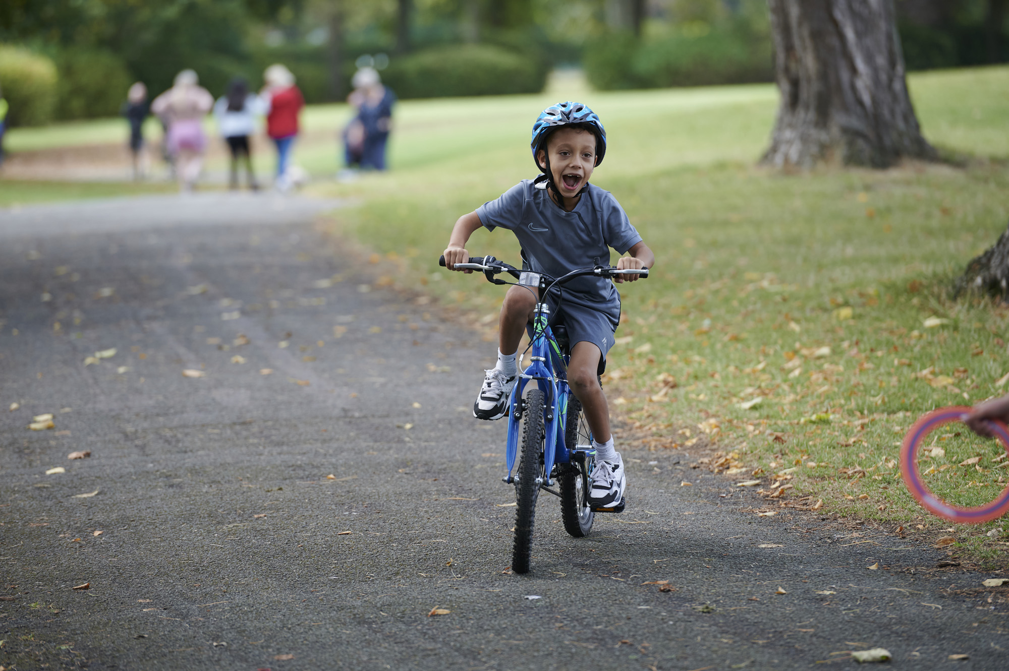 Young boy, wearing helmet, on bike in Moor Park